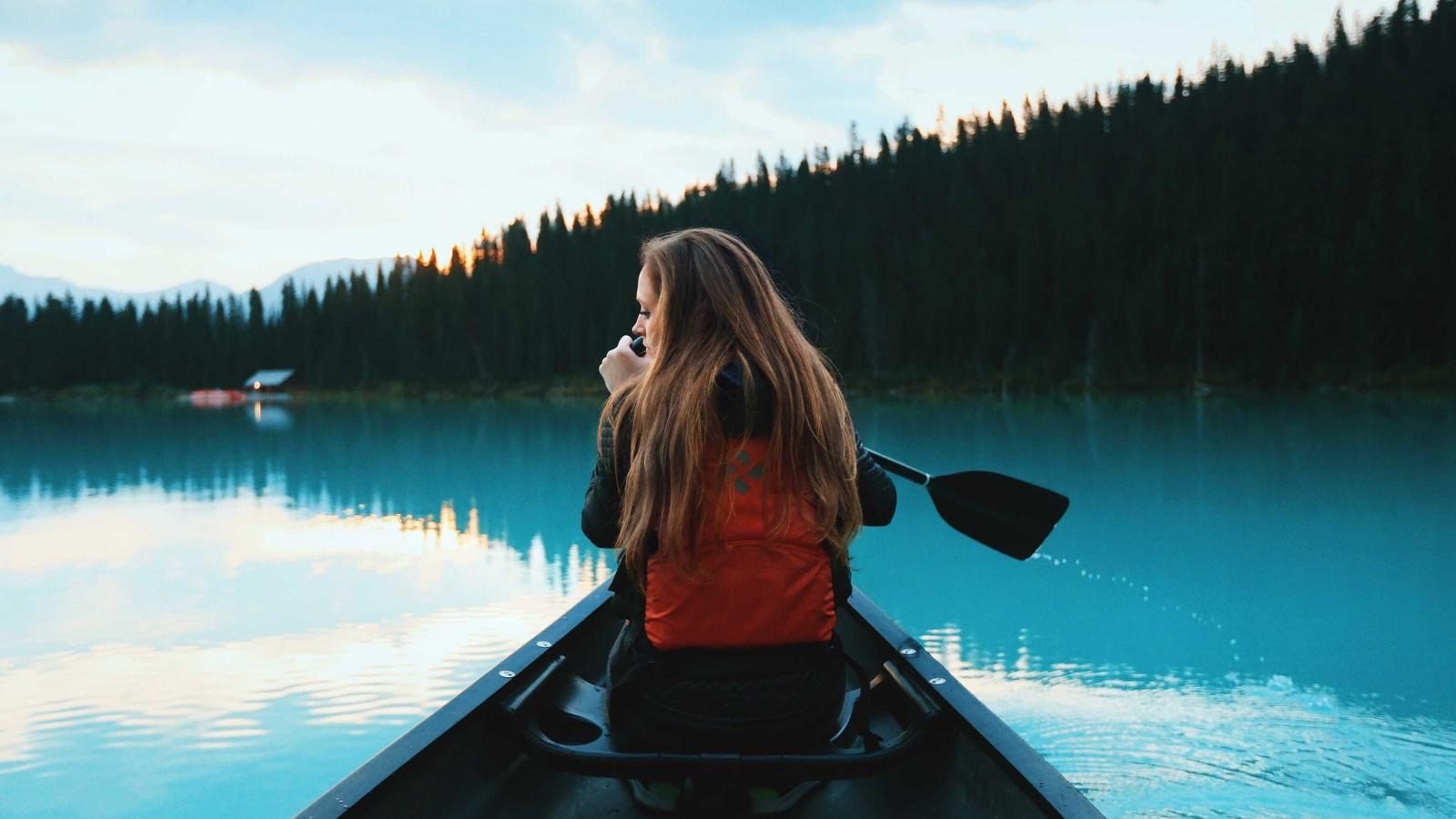 Traveler canoeing on a clear lake